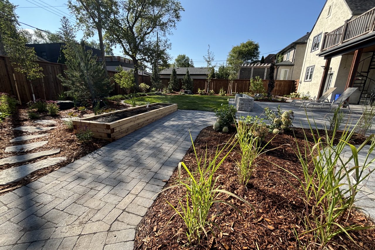 Limitless Landscaping softscaping and patio design in Winnipeg, Manitoba, featuring garden beds and stone pathways.