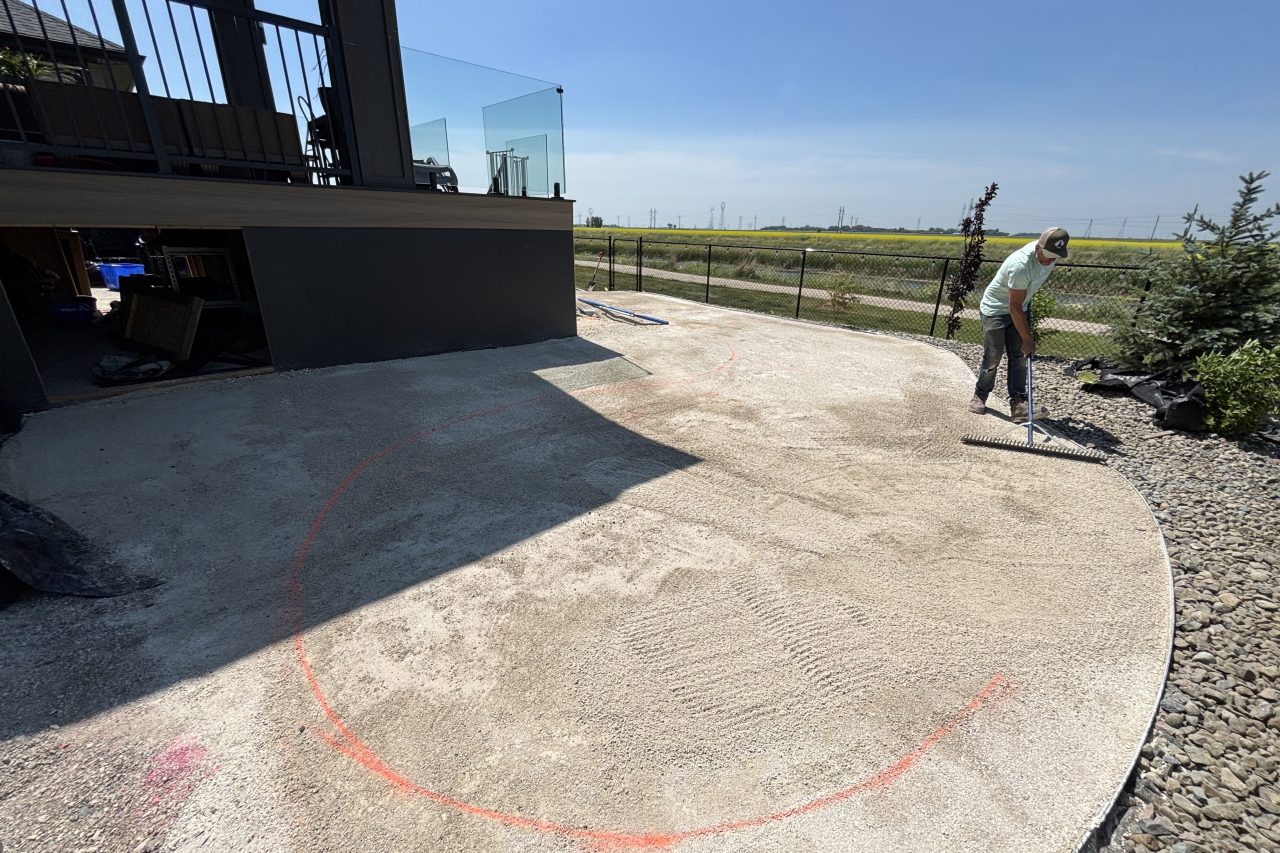 Limitless Landscaping patio construction project in Winnipeg, Manitoba with worker preparing the surface.