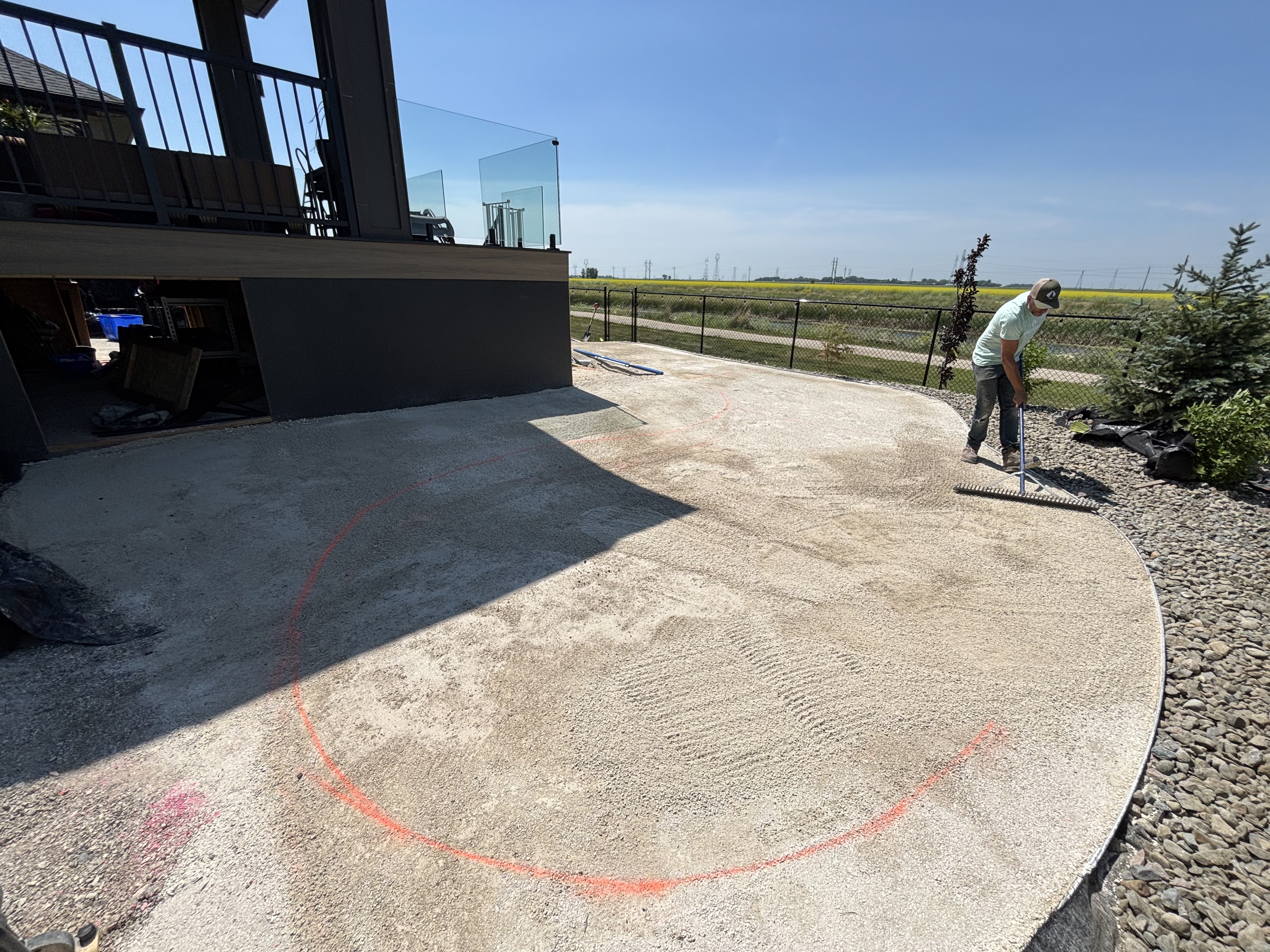 Limitless Landscaping patio construction project in Winnipeg, Manitoba with worker preparing the surface.