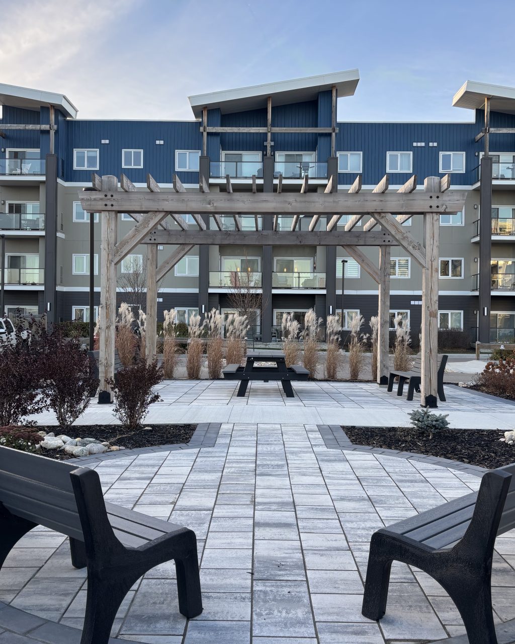 Limitless Landscaping softscaping and patio design in Winnipeg, Manitoba, featuring benches and a pergola.