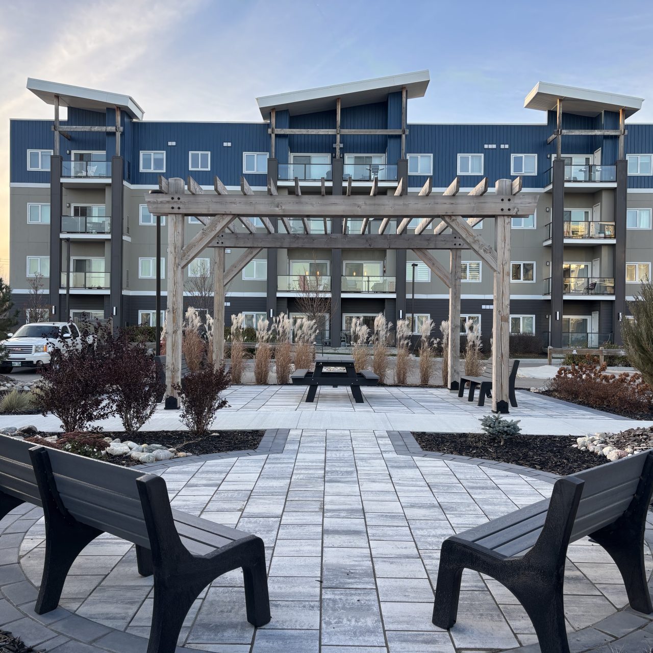 Limitless Landscaping softscaping and patio design in Winnipeg, Manitoba, featuring benches and a pergola.